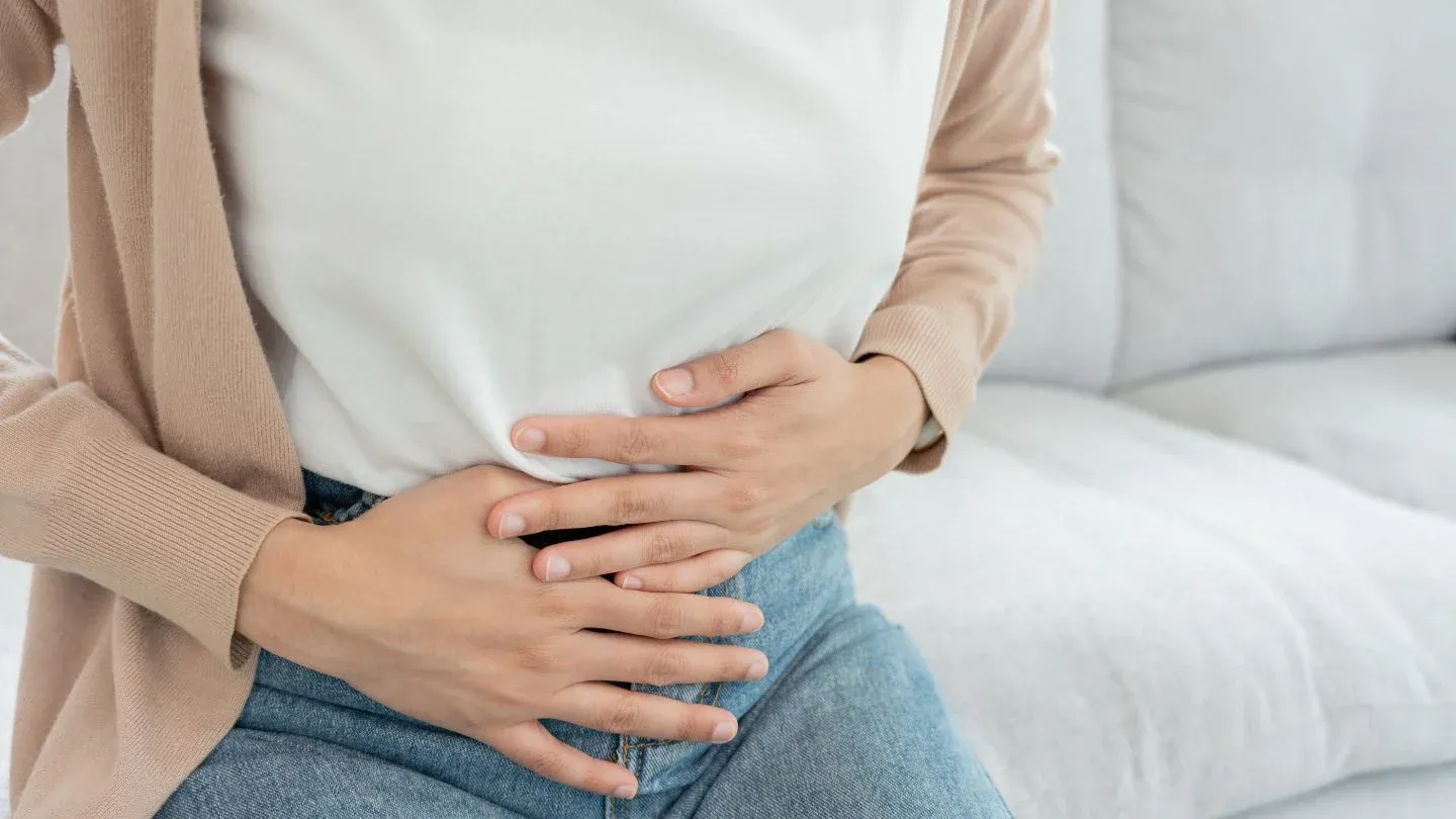 Woman Holding Stomach in Discomfort