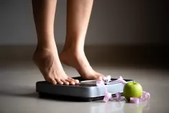 Woman Standing On A Weighing Machine