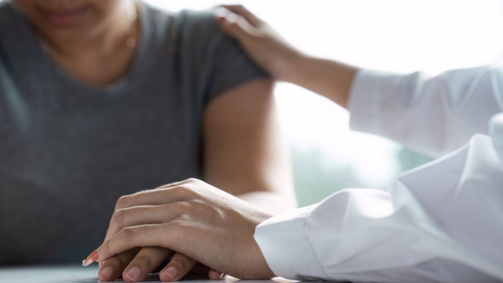 Doctor Comforting A Patient With A Hand On Shoulder
