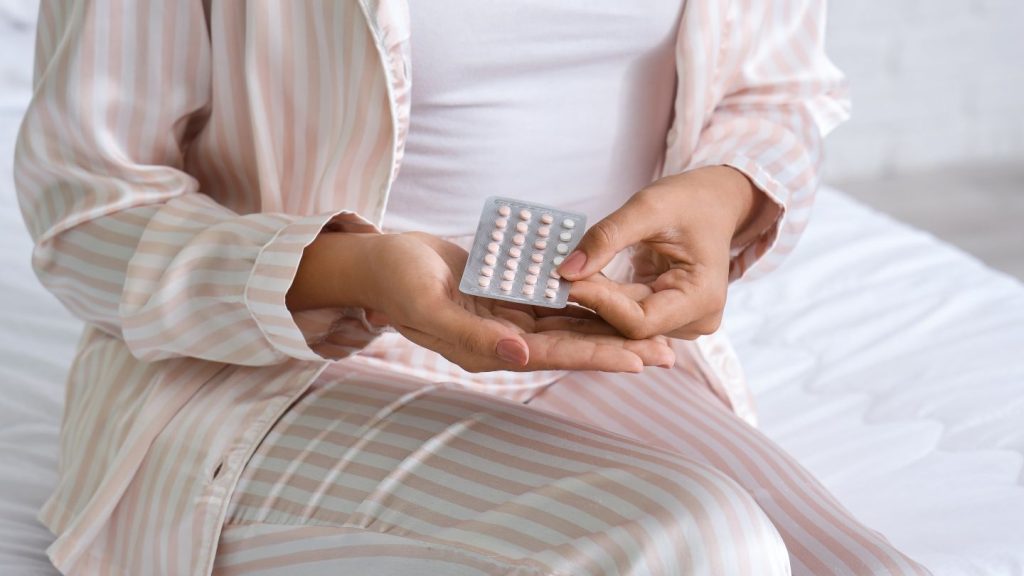 Woman Holding Birth Control Pills
