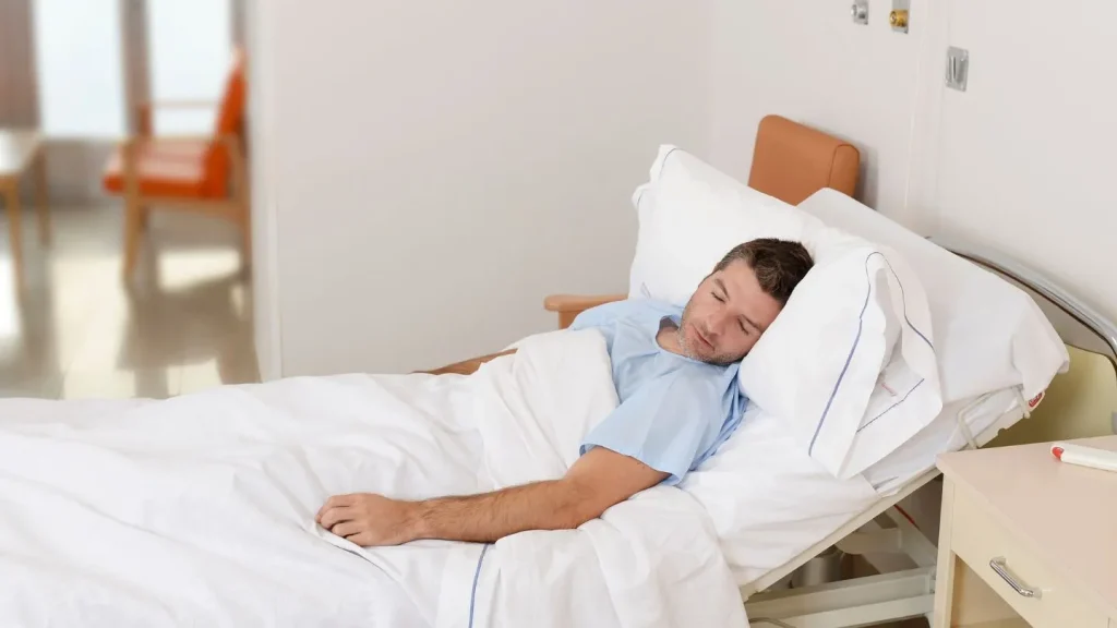 Man Resting In Hospital Bed After Surgery